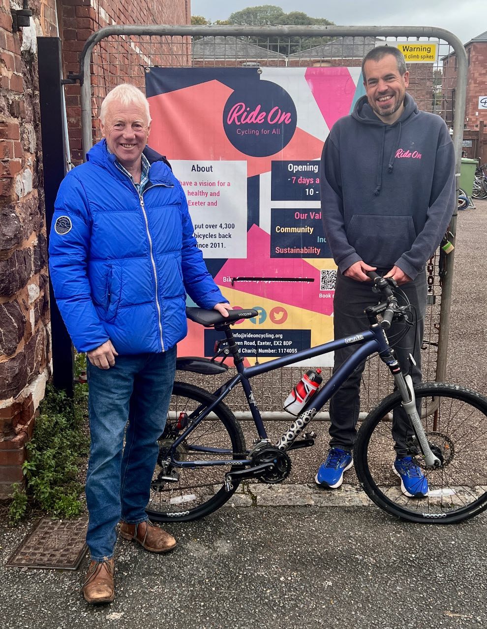 David Greensmith donates his bike to Will Page Head of Charity.